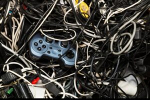 Video game controller tangled in a pile of electronic cables