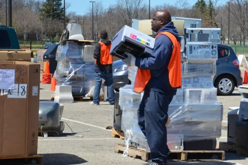 Worker collecting electronics at a municipal recycling event.