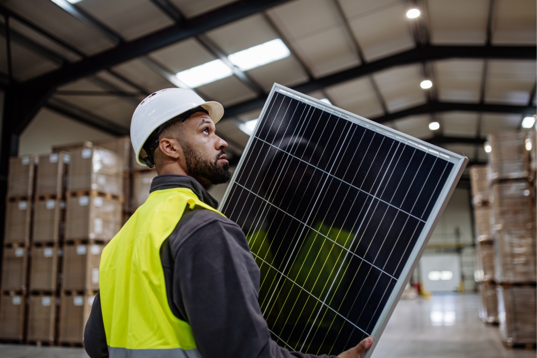 man carrying broken solar panel