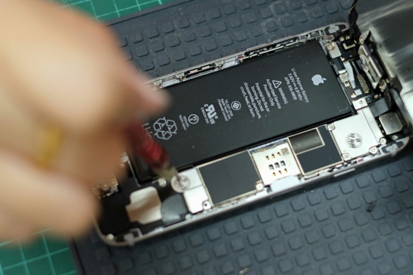Technician removing cell phone battery