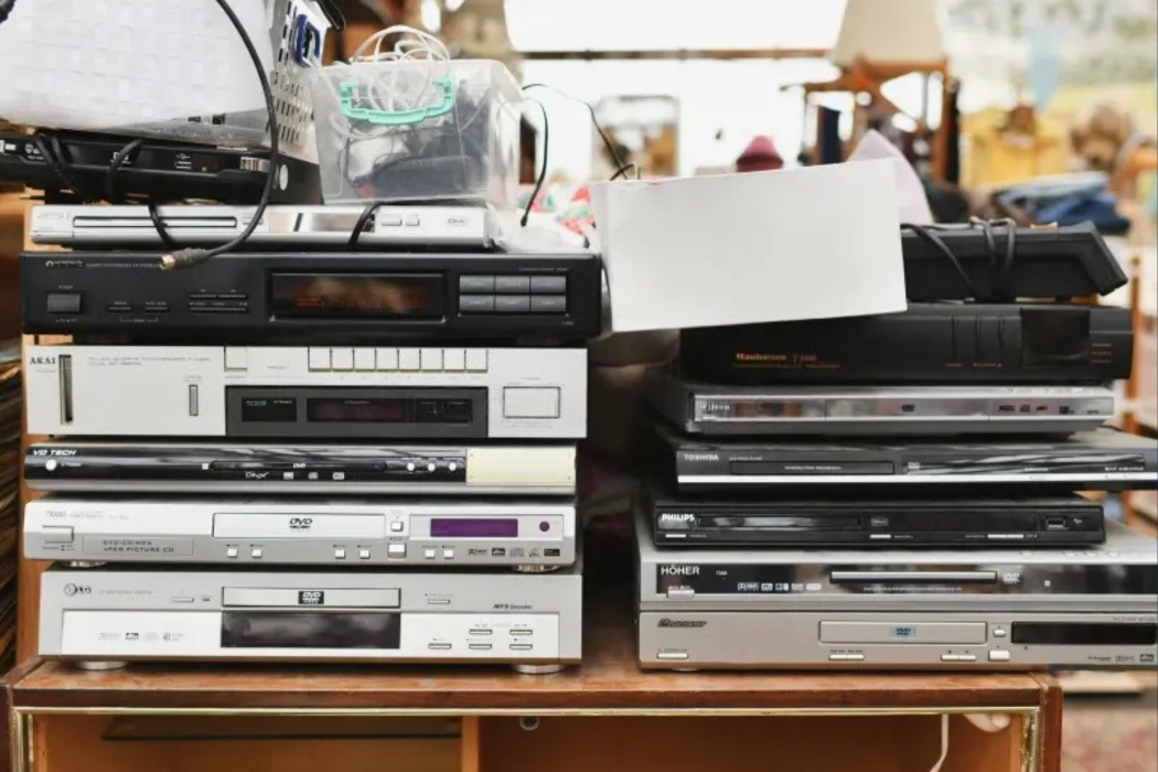 pile of old dvd players for recycling